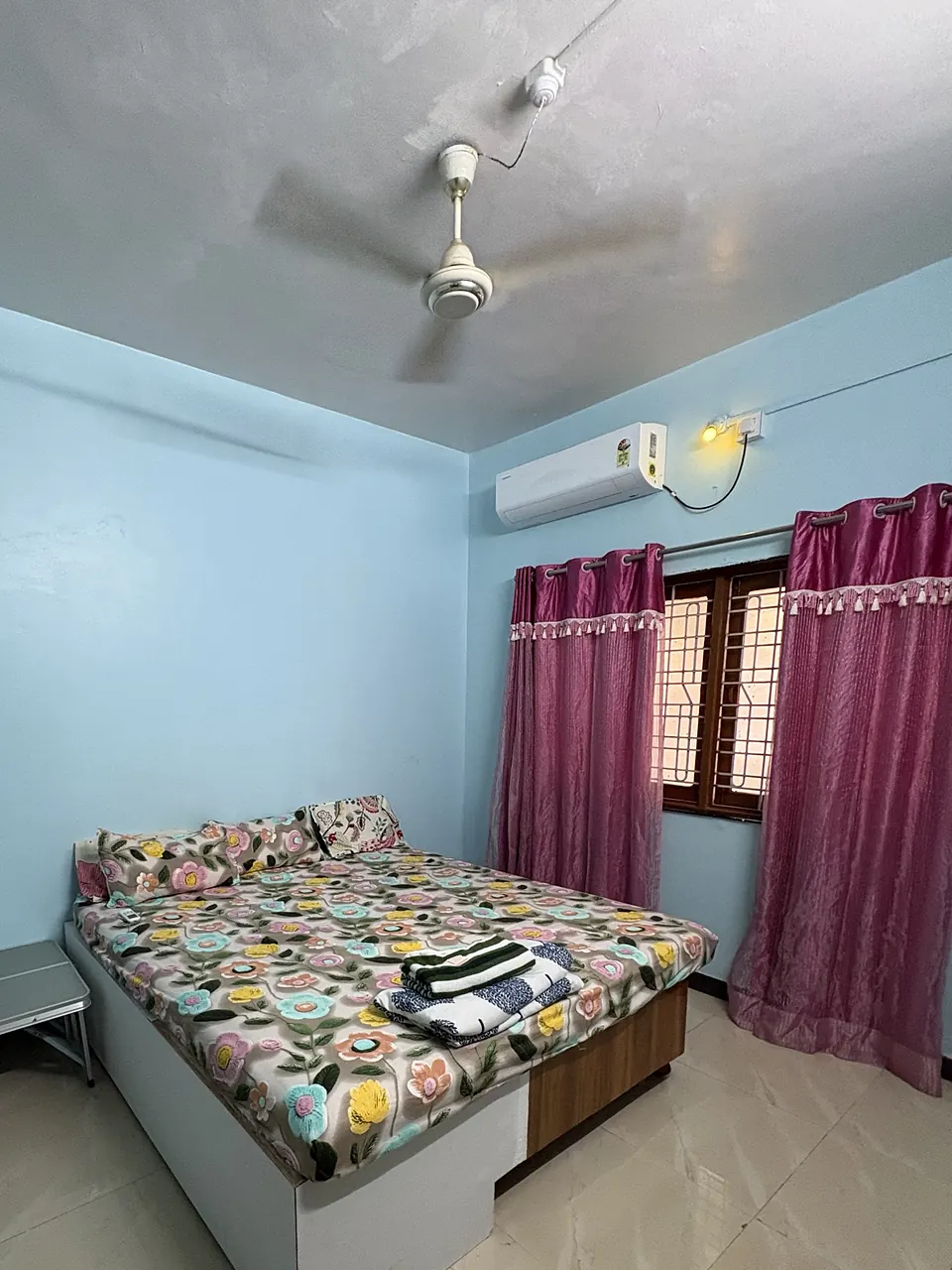 Bedroom seen from the doorway, with the ceiling fan, AC and bed