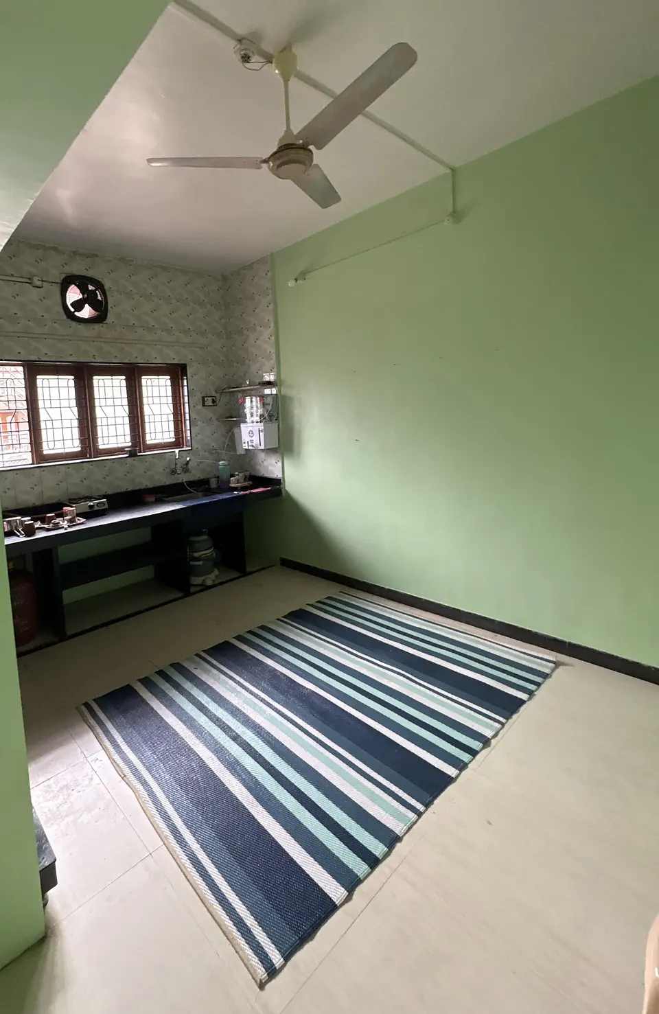 Kitchen with green walls, a black stone counter, a gas stove, an RO water purifier and an exhaust fan