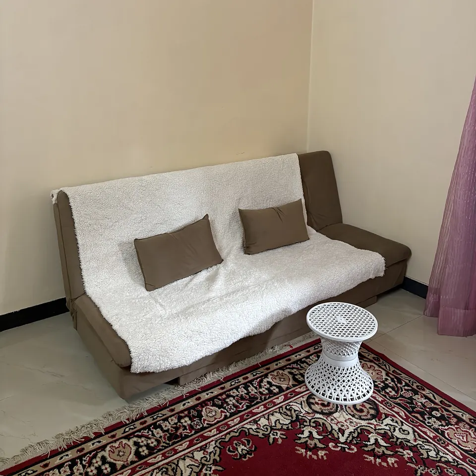 Sofa-cum-bed with a white throw